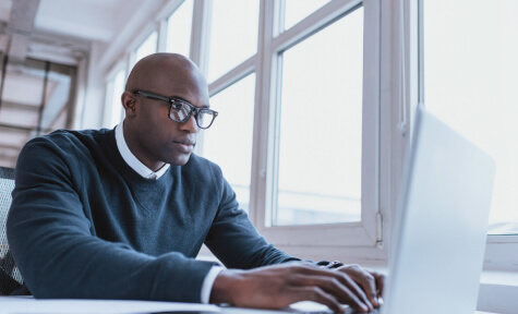 man with eyeglasses using laptop